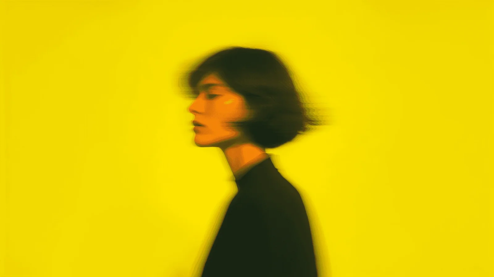A woman in profile against vivid yellow
