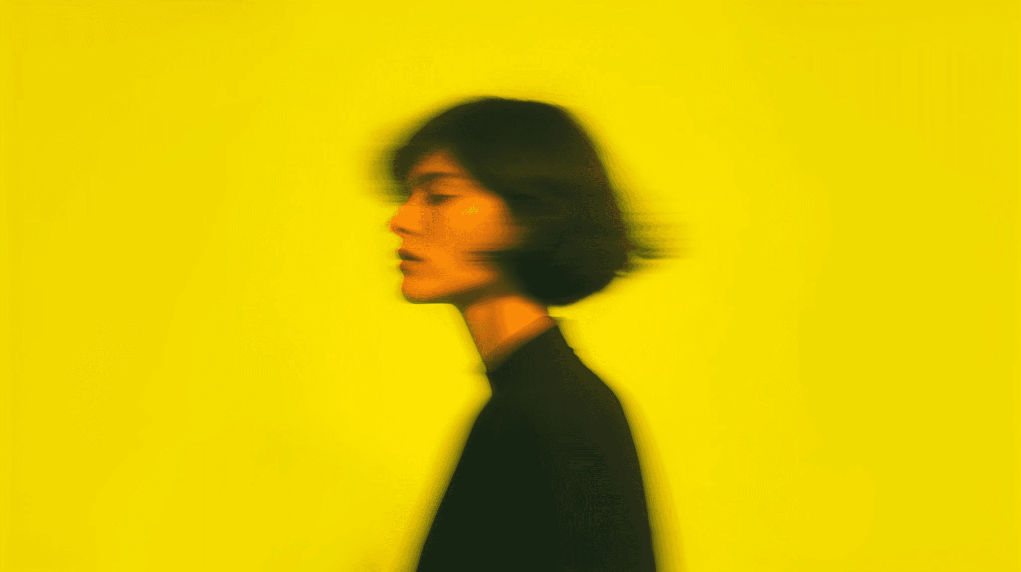 Portrait against a vivid yellow background with a blurred motion effect