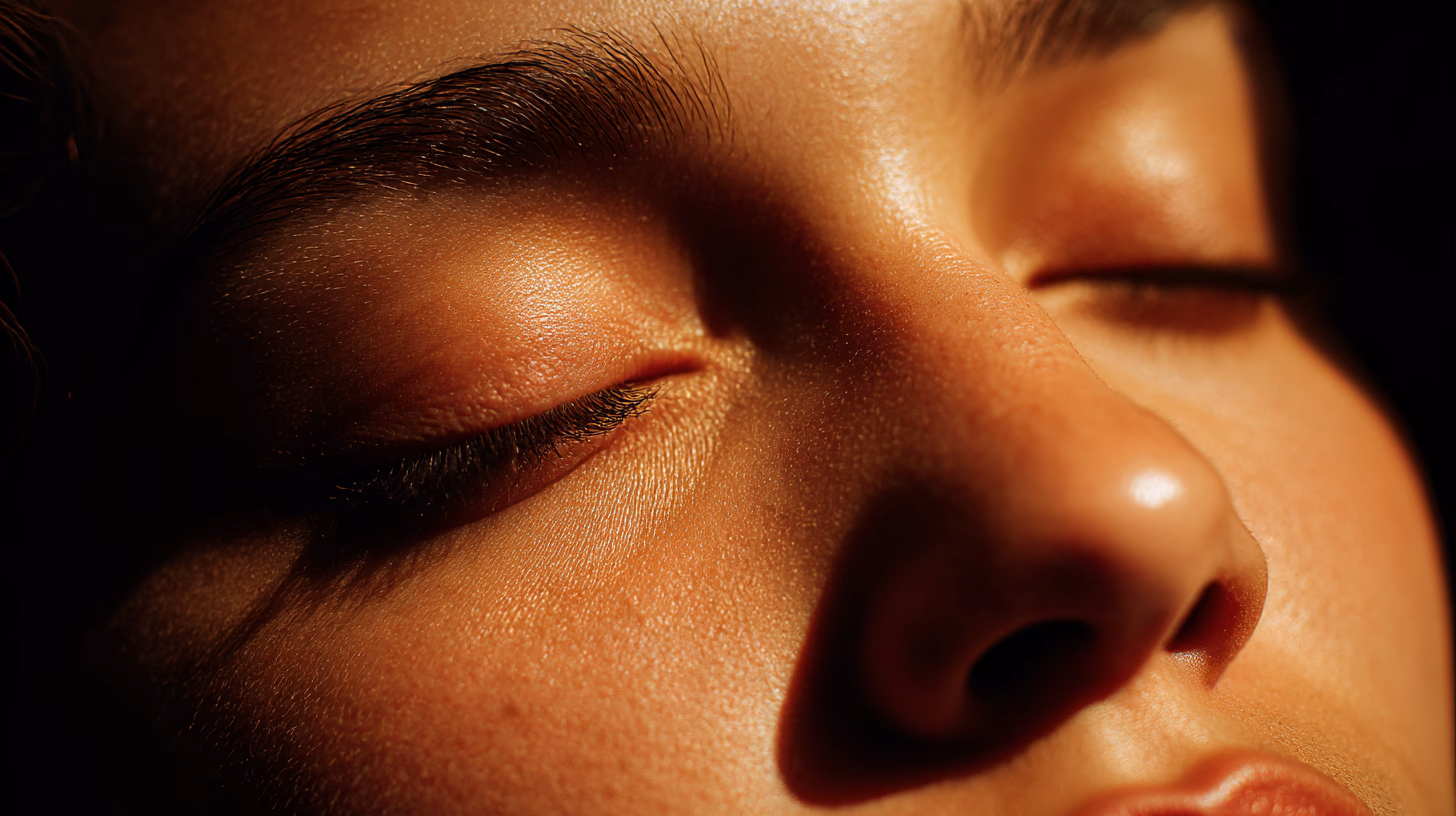 Close-up portrait with closed eyes in warm amber sunlight.